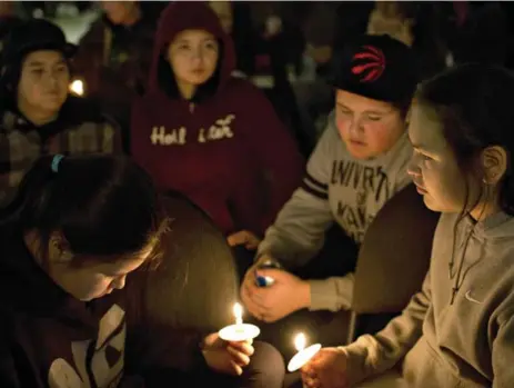  ?? JASON FRANSON/THE CANADIAN PRESS ?? As people gathered for a vigil Sunday in La Loche, one victim’s family called for the country “to listen and respond to create lasting systemic change.”