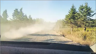  ?? CONTRIBUTE­D ?? This photo shows the dust after a vehicle went past on Highway 358 before a layer of tar was added. The headlights from another vehicle are barely visible and so are the washboard conditions.