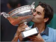  ?? CHRISTOPHE ENA — THE ASSOCIATED PRESS FILE ?? In this June 7, 2009photo, Switzerlan­d’s Roger Federer kisses his trophy after defeating Sweden’s Robin Soderling in their men’s singles final match of the French Open tennis tournament in Paris, France. Roger Federer says he won’t play in the French...