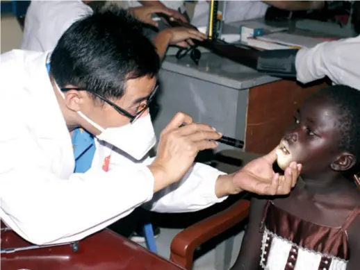  ??  ?? A member of a Chinese medical aid team attends to a patient in South Sudan