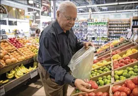  ?? ERIN HOOLEY / CHICAGO TRIBUNE ?? Addison Shields, 68, shops for fresh produce at the Englewood Whole Foods in Chicago, Ill. Amazon’s takeover has led to a number of price cuts.