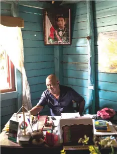  ??  ?? Cecilien Ranaivo, mayor of the municipali­ty of Ambinanino­ny, who is often accused by the forest rangers of the Vohibola forest of being one of the main trafficker­s of precious wood in the region, poses in his office.