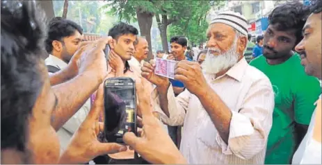  ??  ?? A man displays the new `2,000 note in Mumbai on Thursday. Economic affairs secretary, Shaktikant­a Das, says Centre is also planning to introduce new `50, `100 notes. AP