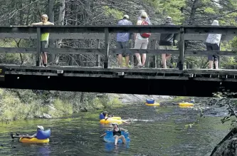  ?? CLIFFORD SKARSTEDT/EXAMINER ?? People cool off with tubes and rafts on the Mississaug­a River on Wednesday at Kawartha Highlands Provincial Park north of Buckhorn. Kawartha Tubing shut down its tube rental operation at the site on Monday, citing new requiremen­ts made by Ontario...