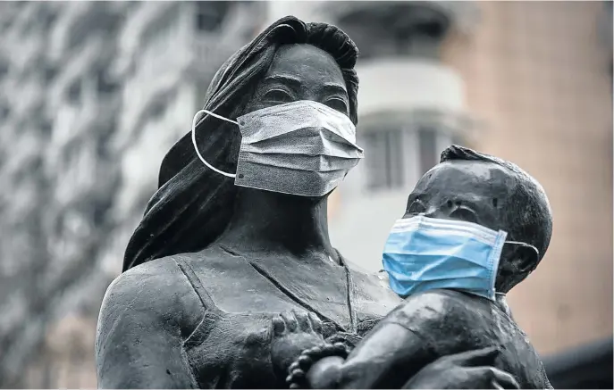  ?? Picture: Getty Images ?? The face masks attached to a statue in Wuhan, China — ground zero of the Covid-19 pandemic — are adverts for good hygiene, but cynics might see them as gags to prevent the spread of the truth about the virus in China.