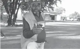  ??  ?? Mr Mthetho Sikhosana from Jimila rural area searches for a cellphone network connection at a spot where villagers have identified as a place where one’s phone catches a signal from only one particular network at Jimila Business Centre in Tsholotsho...