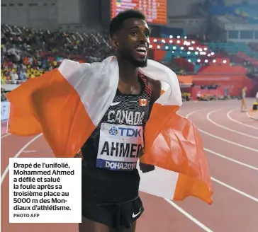  ?? PHOTO AFP ?? Drapé de l’unifolié, Mohammed Ahmed a défilé et salué la foule après sa troisième place au 5000 m des Mondiaux d’athlétisme.