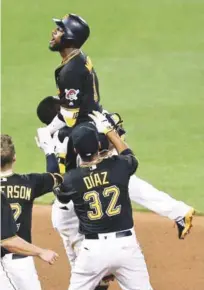  ?? AP ?? Straling Marte es levantado por su compañero Gregory Polanco luego de conectar el batazo que decidió la victoria de los Piratas.