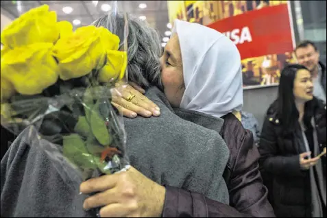  ?? HIROKO MASUIKE / THE NEW YORK TIMES ?? Asia Khoja (right) and her Kurdish Syrian refugee family were welcomed at John F. Kennedy Airport in New York last week after President Donald Trump’s travel ban was put on hold.