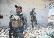  ??  ?? Iraqi forces stand in the rubble of a building Sunday as they advance toward Mosul’s Old City.