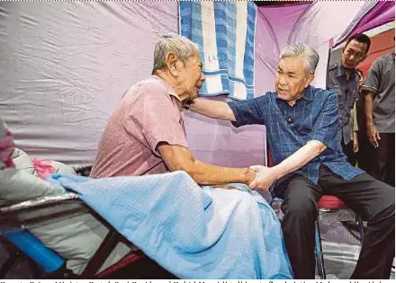  ?? BERNAMA PIC ?? Deputy Prime Minister Datuk Seri Dr Ahmad Zahid Hamidi talking to flood victim Mahayuddin Abd Hashim during a visit to an evacuation centre in Bagan Datuk yesterday.