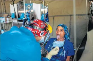  ?? /AFP ?? Taking precaution­s: A health worker performs a swab test for Covid-19 on another health worker at the screening and testing tents set up at the Charlotte Maxeke Hospital in Johannesbu­rg.