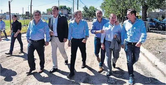  ?? (LA VOZ) ?? Difícil de reunir. Mario Negri, Pedro Dellarossa, Rogelio Frigerio, Héctor Baldassi, Luis Juez y Ramón Mestre, ayer, por las calles de Marcos Juárez.