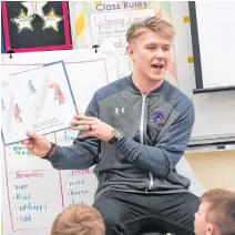  ??  ?? Halifax Thunderbir­ds’ Kyle Jackson reads to students at Caudle Park Elementary last January.