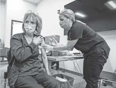  ?? PHOTOS BY MICHELLE PEMBERTON/USA TODAY NETWORK ?? Nursing student Brandi White, right, injects her mother, Angie Stark, with the Pfizer vaccine in Indianapol­is on Jan. 16.