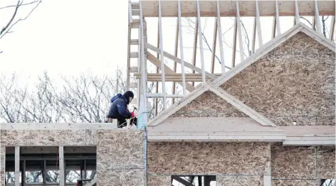  ?? AP PHOTO ?? Constructi­on workers build new housing in Salisbury, Mass.