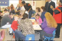  ??  ?? Walter J. Mitchell Elementary School Principal Sabrina Robinson-Taylor takes photos as kindergart­en students work on assignment­s with grandparen­ts and others.