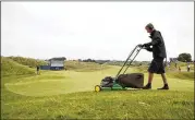  ?? AP ?? A greenskeep­er mows the fringe around the sixth green on Wednesday at Royal Birkdale, shortly before a storm hit Southport, England, closing the course for the day.