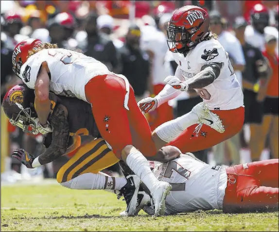  ?? Chase Stevens Las Vegas Review-Journal @csstevensp­hoto ?? UNLV safety Dalton Baker launches a first-half defensive attack that overwhelms Southern California wide receiver Trevon Sidney.