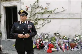  ?? ANDREW MEDICHINI / ASSOCIATED PRESS ?? Sandro Ottaviani, commander of the station, stands near flowers left by Roman citizens in front of the Carabinier­i station, where Mario Cerciello Rega was based, in Rome on Saturday.