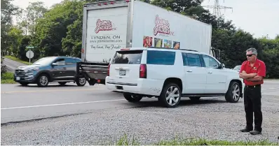  ?? MAC CHRISTIE TORSTAR ?? Dave Jones, who is spearheadi­ng the Turn on Powerline group, at the intersecti­on of Powerline Road West and Highway 52 while a car passes a left-turning vehicle on the gravel shoulder.