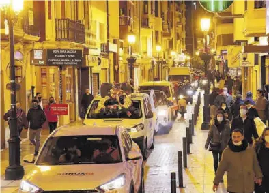  ??  ?? DAVID GARCÍA
La caravana de coches por la calle Mayor. Debajo, Amores pone una corona de flores en la Casa dels Caragols. ((