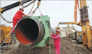  ?? XINHUA ?? Employees work on the constructi­on site of an LNG terminal at Caofeidian of Tangshan in Hebei province in June.