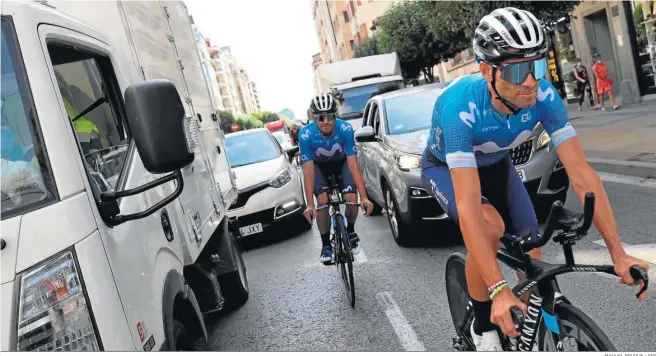  ?? MANUEL BRUQUE / EFE ?? Alejandro Valverde y un compañero del Movistar se ejercitan por las calles de Burgos en la mañana del viernes rodeados de coches.