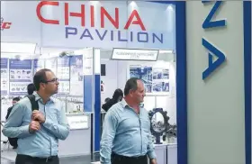  ?? SHAN YUQI / XINHUA ?? Left: Visitors attend China’s booth at Germany’s Hannover Messe last year.