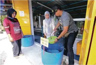  ??  ?? MELAYAN pelanggan yang datang mendapatka­n bekalan ikan.