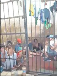  ??  ?? Un grupo de presos aguanta como puede una tormenta durante la cual cae más agua adentro que afuera.