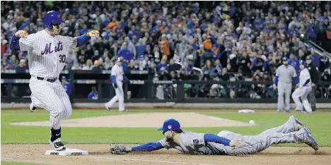  ?? DAVID J. PHILLIP/THE ASSOCIATED PRESS ?? The New York Mets’ Michael Conforto is safe at first as the Kansas City Royals’ Eric Hosmer makes a diving attempt during the fourth inning of Game 3 of the World Series on Friday night in New York. The Mets won 9-3 to trim the Royals’ series lead to...