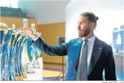  ?? REAL MADRID / EFE ?? Sergio Ramos observa los trofeos ganados con el Madrid.