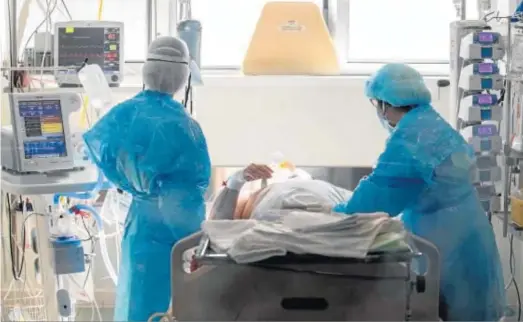  ?? MARCIAL GUILLÉN / EFE ?? Dos enfermeras atienden ayer a un paciente de Covid-19 en la UCI del Hospital Reina Sofía de Murcia.
