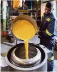  ?? Foto: Philip Mostert/Rand Refinery, dpa ?? Mitarbeite­r mit Goldgranul­at in der Fa brik in Südafrika: Das Gold wird erst ver feinert, später werden Münzen geprägt.