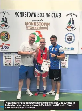  ??  ?? Megan Bainbridge celebrates her Monkstown Box Cup success in Ireland with her father and coach Paul (left) and Brandon Boxing Club coach Simon Patterson