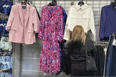  ?? (AP/Anne D’Innocenzio) ?? A shopper looks at clothes at a Walmart in Secaucus, N.J., on March 25.