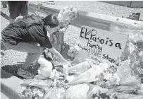  ?? MARK RALSTON/GETTY-AFP ?? A woman on Sunday places flowers at a memorial outside an El Paso Walmart, where 20 people were killed Saturday.