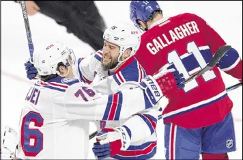  ?? RYAN REMIORZ / THE CANADIAN PRESS ?? Rangers left wing Tanner Glass (center) celebrates with teammate Brady Skjei after scoring the opening goal Wednesday night at Montreal.