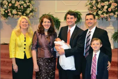  ?? The Associated Press ?? WFF COMPOUND: In this 2012 photo provided by a former member of the church, Jeffrey Cooper holds his infant daughter at her 2012 baby dedication at the Word of Faith Fellowship compound in Spindale, N.C. At second right is Frank Webster, an assistant...