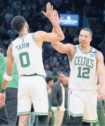  ?? STEVEN SENNE/AP ?? Jayson Tatum and Grant Williams high-five during the Celtics’ Game 7 victory over the Bucks on Sunday.
