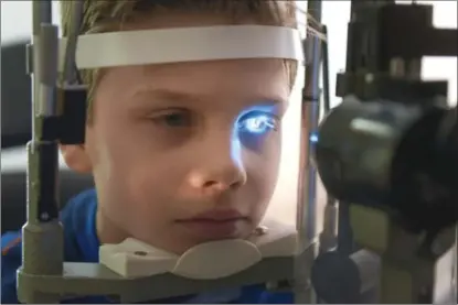  ?? SCOTT GARDNER, THE HAMILTON SPECTATOR ?? Dr. Kourosh Sabri uses a split lamp microscope to check Keyvan Mehta-Owens’ eye at McMaster Children’s Hospital Wednesday. The 10-year-old was diagnosed with a blind eye at seven, but the early diagnosis allowed him to regain his sight before it was...