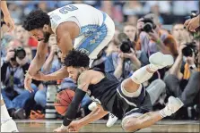  ?? David J. Phillip / The Associated Press ?? Gonzaga’s Josh Perkins (bottom) and North Carolina’s Joel Berry II collide as they reach for a loose ball during the second half of Monday’s game.