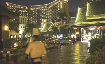  ??  ?? A cook walks through the Yalong Bay Mangrove Tree Resort, operated by Antaeus Group, at night in Sanya.