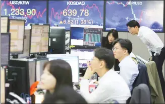  ??  ?? Currency traders watch monitors at the foreign exchange dealing room of the KEB Hana Bank headquarte­rs in Seoul, South Korea, Monday, April 27. Asian stock markets have gained after Japan’s central bank promised to buy more government bonds to support financial markets as investors look to central bankers to shore up the
struggling global economy. (AP)