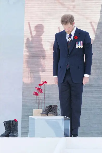  ?? ANDY COMMINS / POOL / GETTY IMAGES ?? Prince Harry stands at attention in front of combat boots symbolizin­g Canada’s fallen soldiers at the Battle of Vimy Ridge 100th anniversar­y commemorat­ion Sunday at the Vimy Memorial in northern France.