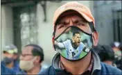  ?? PTI ?? A public transport driver, wearing a protective face mask emblazoned with an image of Lionel Messi, attends a protest demanding an increase in fares because quarantine measures to curb the spread of the new Coronaviru­s have decreased his income, in La Paz, Bolivia