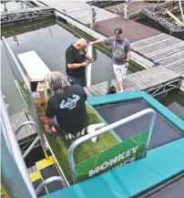  ??  ?? Michael Johnson, Patrick Fox and Mike Johnson, from left, stand on the Jungle Float on Friday at Big Ridge Marina.