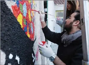  ?? ?? Afghan artist Omaid Sharifi, one of the co-founders of Artlords, paints a wall mural Thursday.