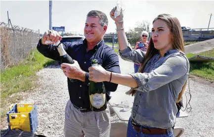  ?? Michael Wyke ?? Scott Jones, director of advocacy for the Galveston Bay Foundation, and Jackie Young with the Texas Health and Environmen­t Alliance pop bottles of champagne before the start of a news conference Thursday at the San Jacinto River Waste Pits.